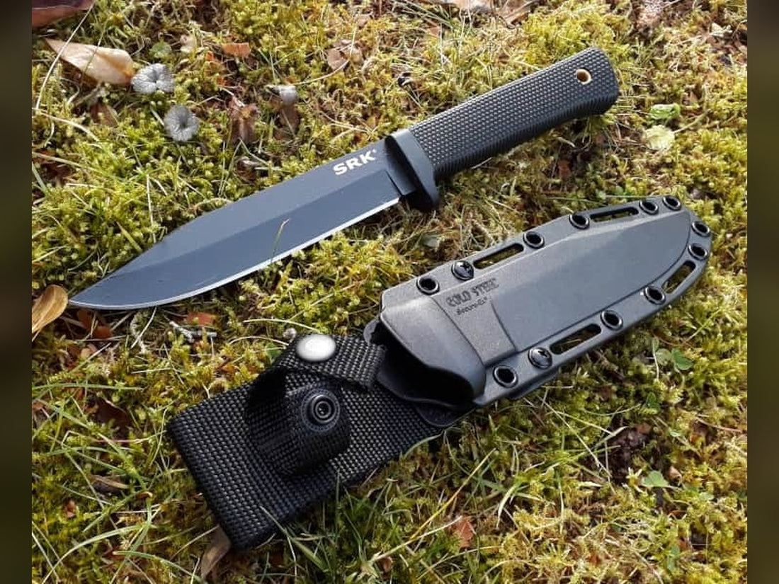 Cold Steel SRK fixed blade knife with its Secure-Ex sheath lying on moss and grass outdoors